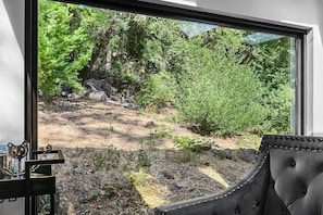 A view through a window with a landscape of trees and rocks. - Calistoga Retreat | Family Friendly + Private Pool (Calistoga)