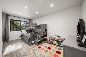 A child's bedroom with bunk beds, a desk, and a TV. - Calistoga Retreat | Family Friendly + Private Pool (Calistoga)