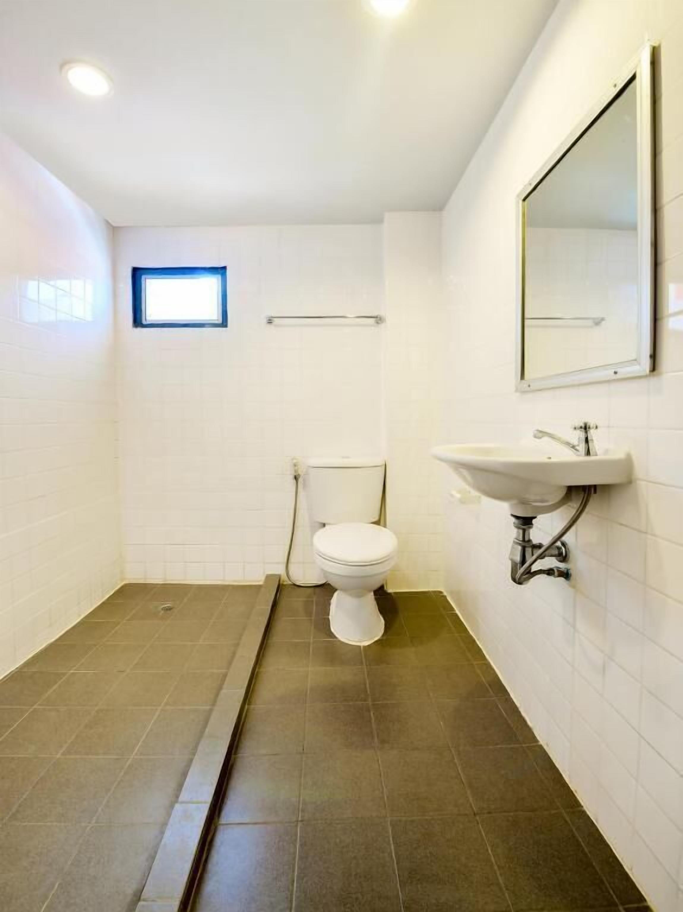 A small, compact bathroom with a toilet, sink, and a window.