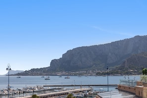 A marina with boats docked, a clear sky, and a mountainous backdrop. - Mondello Holidays - Casa Goethe Apartment with Sea View, WiFi, and Air Conditioning (Palermo)