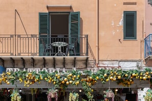 A building facade with a balcony, a table, and chairs. - Mondello Holidays - Casa Goethe Apartment with Sea View, WiFi, and Air Conditioning (Palermo)