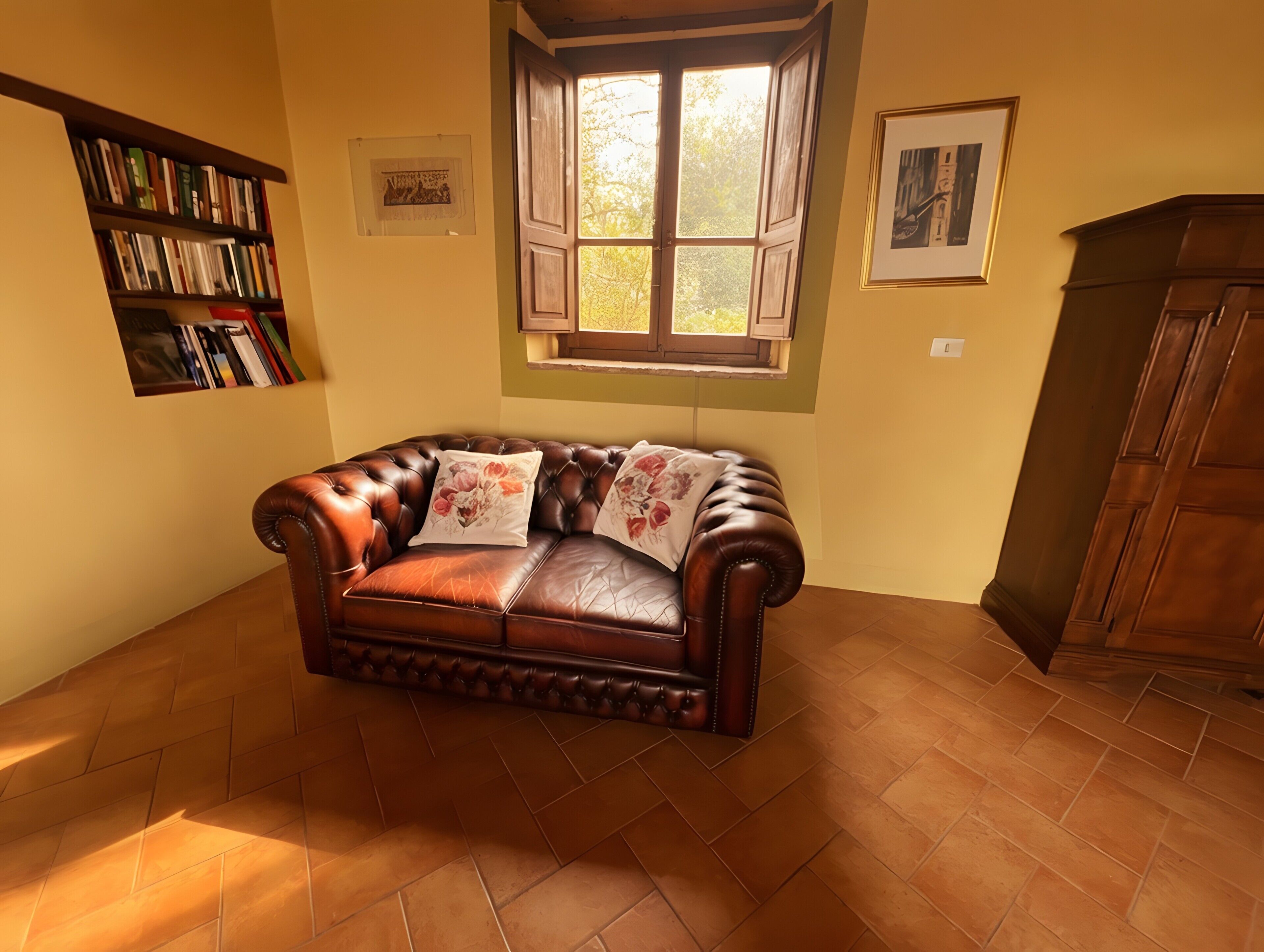 A room with a leather sofa, a bookshelf, a window with open shutters, and a wooden cabinet.