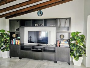A modern entertainment center with a flat-screen TV, built-in shelves, and decorative items. - Stunning Spacious Villa with panoramic Sea Views (Estepona)
