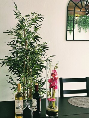 A table with a tall bamboo plant, two wine bottles, and a glass. - Stunning Spacious Villa with panoramic Sea Views (Estepona)