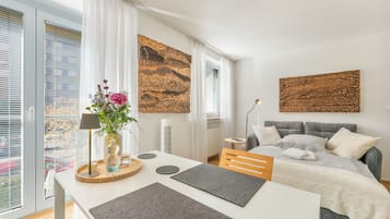 Une chambre à coucher moderne, avec un lit, une table de chevet, une lampe et des œuvres d’art accrochées aux murs.