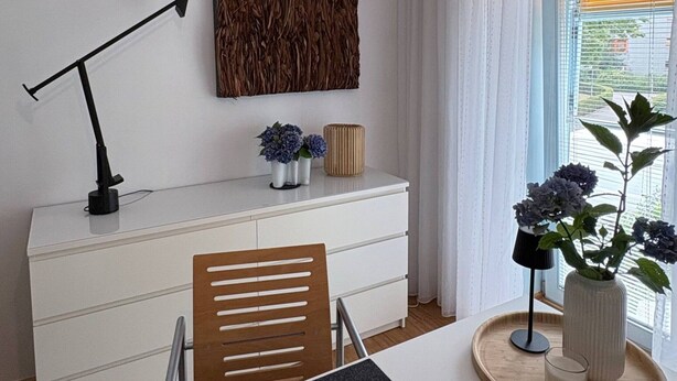 A modern room with a desk, chair, and a decorative wall piece.