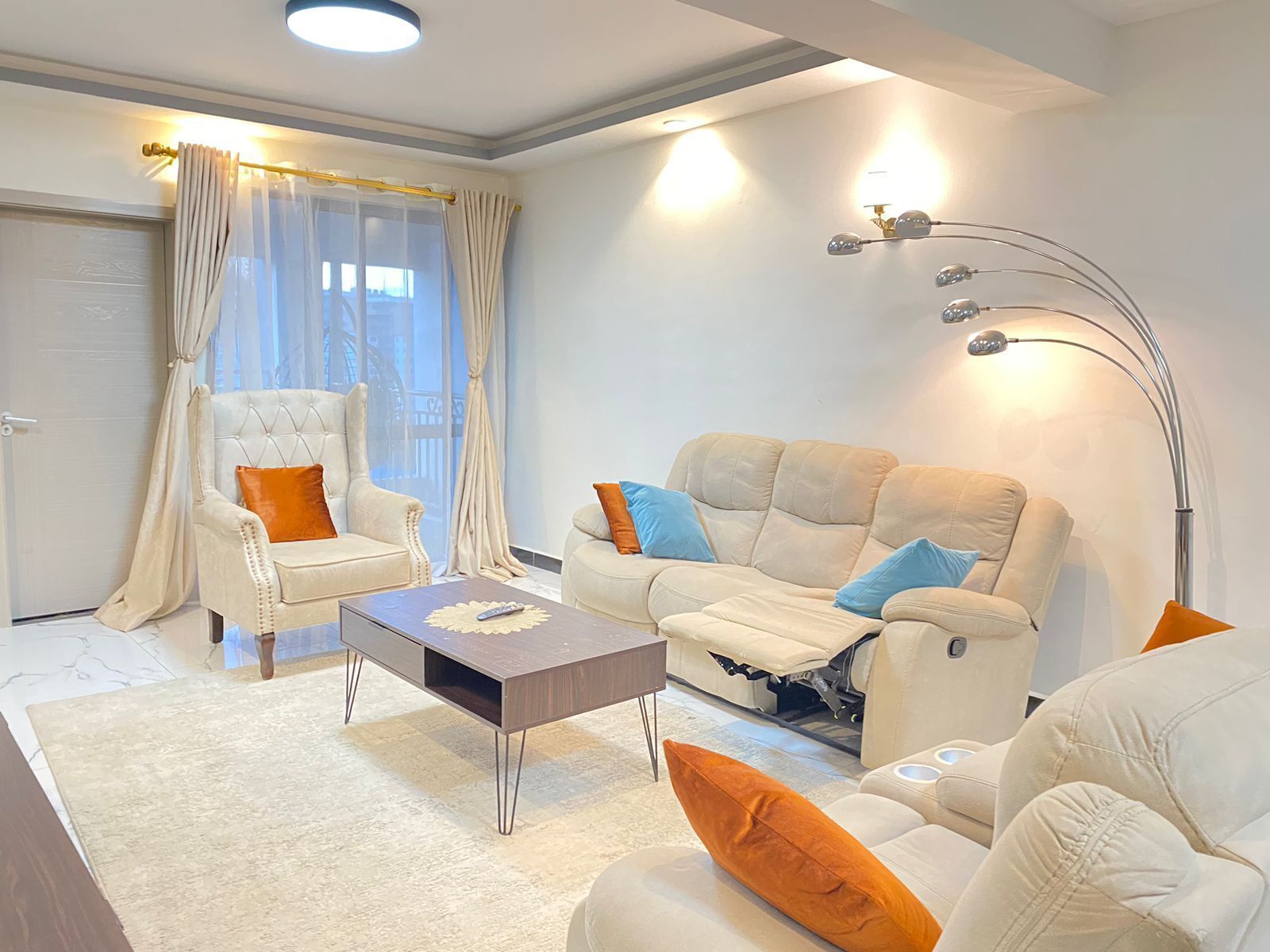 Uma sala de estar moderna com sofá, poltrona e mesa de centro.
