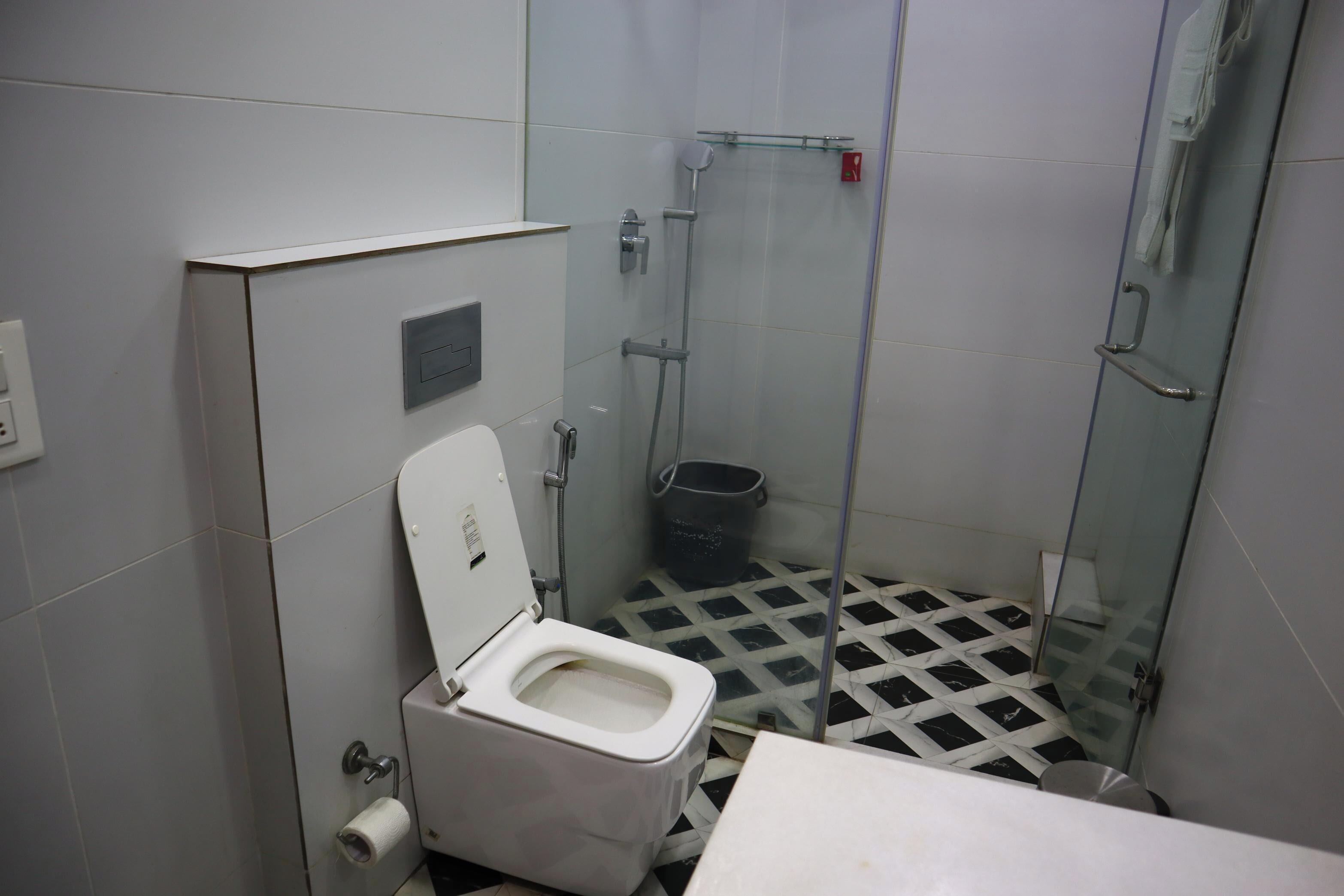 A small bathroom with a toilet, a shower, and a sink.