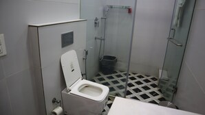 Un baño pequeño con inodoro, ducha y lavabo.