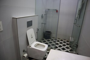 Un baño pequeño con inodoro, ducha y lavabo.