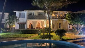 A two-story building with a balcony, a swimming pool, and palm trees. - Oceanfront Hideaway Pool Beach a Coastal Escape (Malindi)