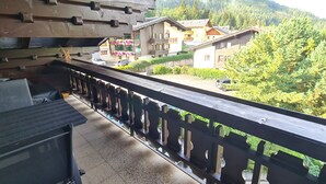 A balcony with a view of a residential area, including houses and trees. - Haus Claudia Top 9 by Globalimmoservice (Bad Kleinkirchheim)