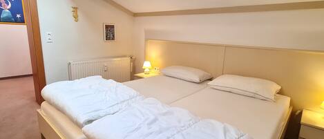 A double bed with a headboard, a bedside lamp, and a wall-mounted picture.