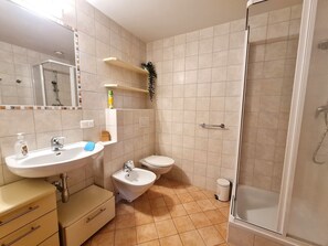 A bathroom with a sink, bidet, toilet, and shower. - Haus Claudia Top 9 by Globalimmoservice (Bad Kleinkirchheim)