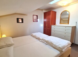 A bedroom with a bed, a dresser, a mirror, and a wall-mounted picture. - Haus Claudia Top 9 by Globalimmoservice (Bad Kleinkirchheim)