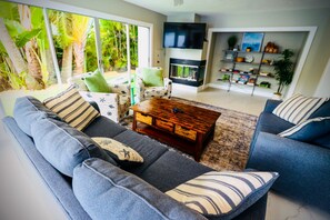 Ein modernes Wohnzimmer mit einer Couch, einem Couchtisch und einem Fernseher.