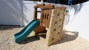A sand play area with a slide and climbing structure. - Twin Tides Large Home Heated Pool Spa Putting Green Golf Cart Tiki Bar Ping Pong Sleeps 14 (Holmes Beach)