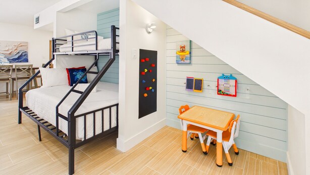 A child's room with bunk beds, a desk, and educational toys on the wall. - Twin Tides Large Home Heated Pool Spa Putting Green Golf Cart Tiki Bar Ping Pong Sleeps 14 (Holmes Beach)