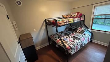 A bunk bed room with a window, a door, and a small closet.