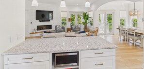 A spacious kitchen with a large island, built-in appliances, and a dining area with natural light. - Fanta Sea Pool Hot Tub Game Room 7 Minute Walk to the Beach (Holmes Beach)
