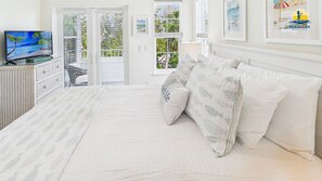 A bedroom with a bed, pillows, a television, and a window with blinds. - Fanta Sea Pool Hot Tub Game Room 7 Minute Walk to the Beach (Holmes Beach)