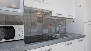 A kitchen with a built-in microwave, a stainless steel sink, and a gas stove. - Loft Lingotto by Wonderful Italy (Turin)