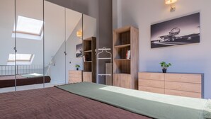 A bedroom with a bunk bed, a wooden dresser, a mirror, and a framed picture on the wall. - Loft Lingotto by Wonderful Italy (Turin)