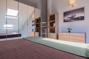 A bedroom with a bunk bed, a wooden dresser, a mirror, and a framed picture on the wall. - Loft Lingotto by Wonderful Italy (Turin)