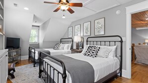 A bedroom with two beds, a ceiling fan, and artwork on the walls. - McLemore Resort - 68 Founder Path - Walking distance to Range and Clubhouse (Rising Fawn)