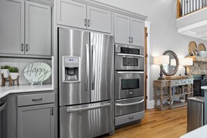 A stainless steel refrigerator with a water dispenser, a built-in oven, and a microwave.