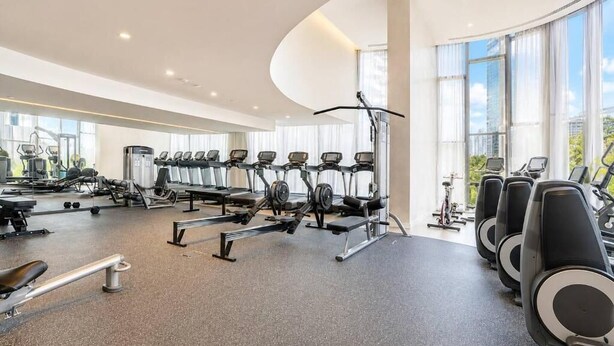 Uma academia moderna com esteiras, máquinas de peso e equipamentos de exercício.