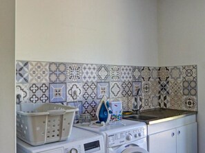 A laundry area with a washing machine, a dryer, and a sink.