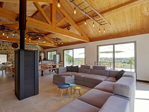 A spacious living area with a large sectional sofa, a fireplace, and a view of the outdoors. - Renovated house, private pool - 18 guests (Sail-les-Bains)
