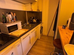 A compact kitchen with a microwave, sink, and dishwasher. - Charming apartment near the sea - 4 guests (Blonville-sur-Mer)