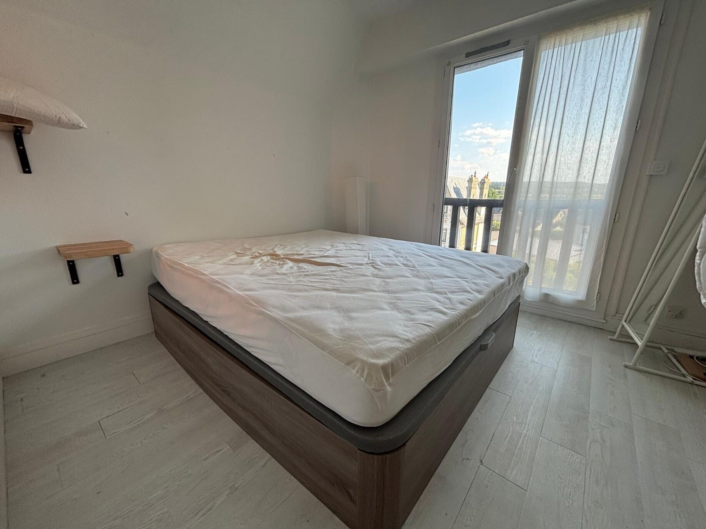 Ein Schlafzimmer mit Bett, einer Holzkammer, einem Fenster mit Aussicht und einem Balkon.