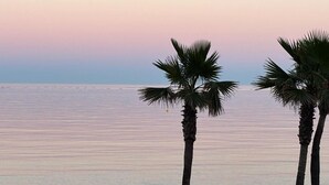 A beach scene with palm trees and calm water. - Elegant apartment, sea view, AC - 4 guests (Torremolinos)