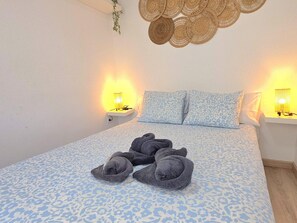 Ein Schlafzimmer mit einem Bett, zwei Nachttischen mit Lampen und einer Wanddekoration.