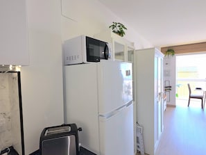 Eine kleine Küche mit Mikrowelle, Kühlschrank und Toaster.