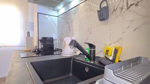 Una cocina moderna con un lavamanos integrado, una cafetera y un hervidor.