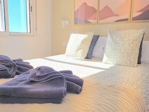 Ein Hotelzimmer mit Bett, Kissen und Handtüchern.