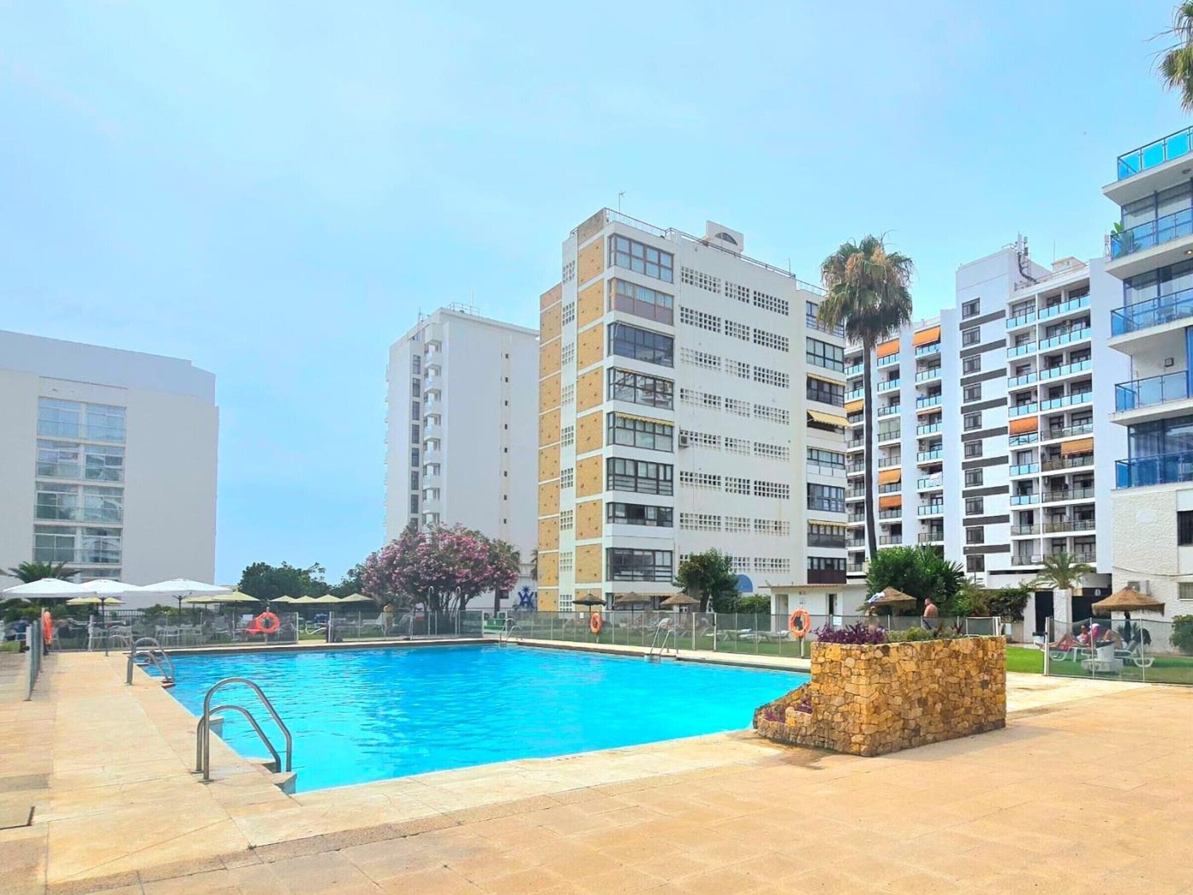 A swimming pool surrounded by modern apartment buildings.