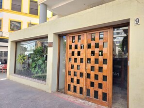 A building entrance with a wooden lattice door and a glass window. - Central apartment with pool - 4 guests (Torremolinos)
