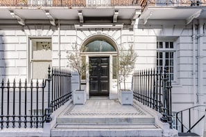 A building facade with a black door, white trim, and a symmetrical black iron fence. - Luxury London Six-Bedroom House in Marylebone - Moments from Regent’s  Park (London)