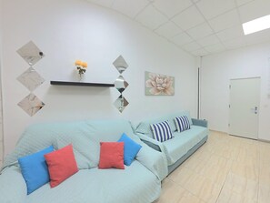 A modern living room with a sofa set, decorative wall mirrors, and a floral artwork. - Spacious central apartment - 5 guests (Torremolinos)