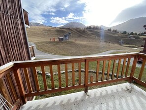 A wooden balcony with a view of a mountainous landscape. - Charming studio, balcony mountain view - 4 guests (Plagne Villages)