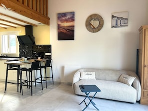 A modern kitchen with a dining area, a sofa, and a small table. - Renovated house close to the beach - 3 guests (Bretignolles-sur-Mer)