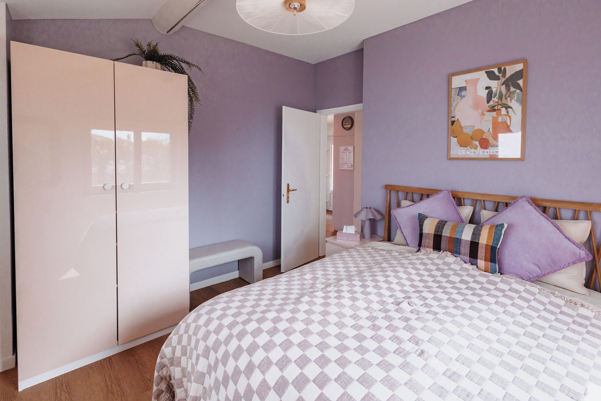 A bedroom with a bed, a wardrobe, and a door leading to another room.