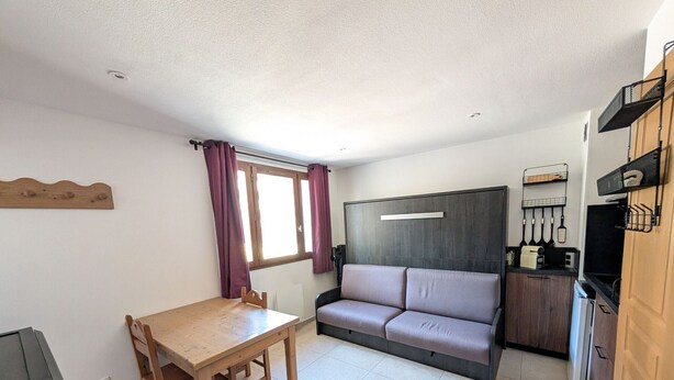 A compact living space with a kitchenette, a dining table, a sofa, and a window with curtains. - Renovated studio facing slopes - 3 guests (Montgenèvre)