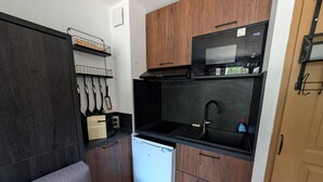 A compact kitchenette with a microwave, sink, and storage cabinets. - Renovated studio facing slopes - 3 guests (Montgenèvre)