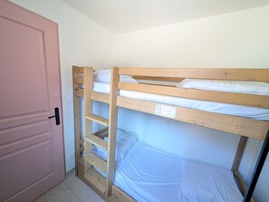 A bunk bed with two levels, a door, and a light switch on the wall. - Renovated studio facing slopes - 3 guests (Montgenèvre)